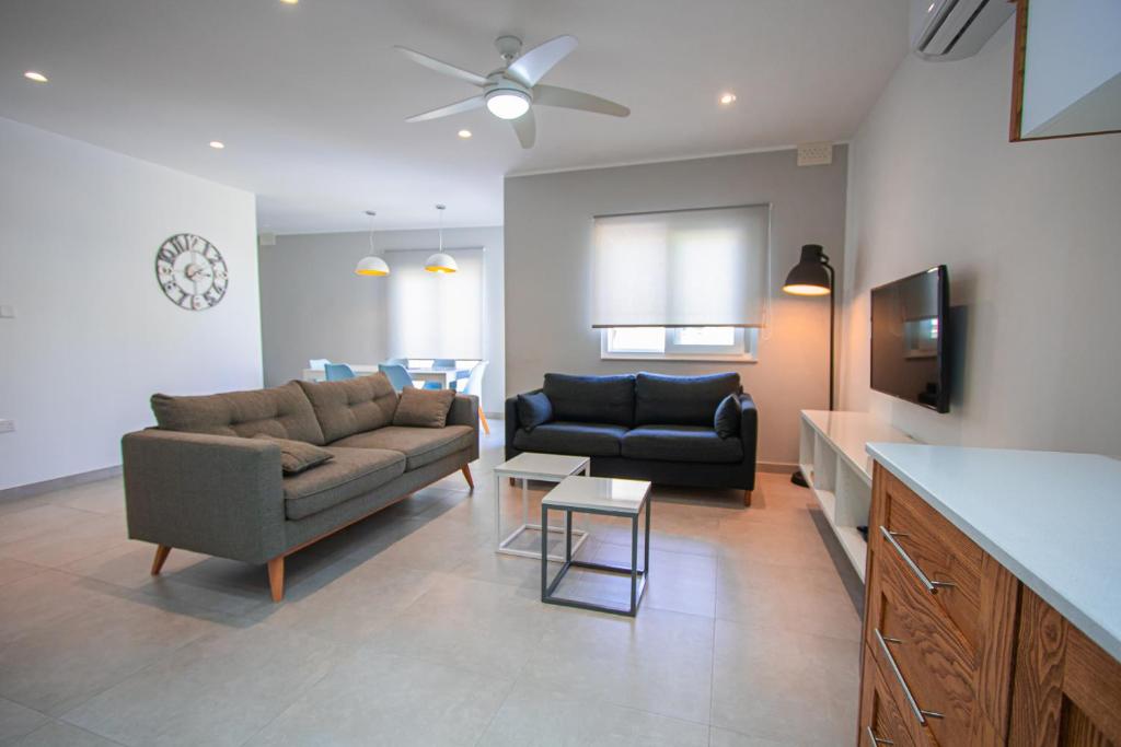 a living room with a couch and a tv at The Three Trees Apartments in Sliema