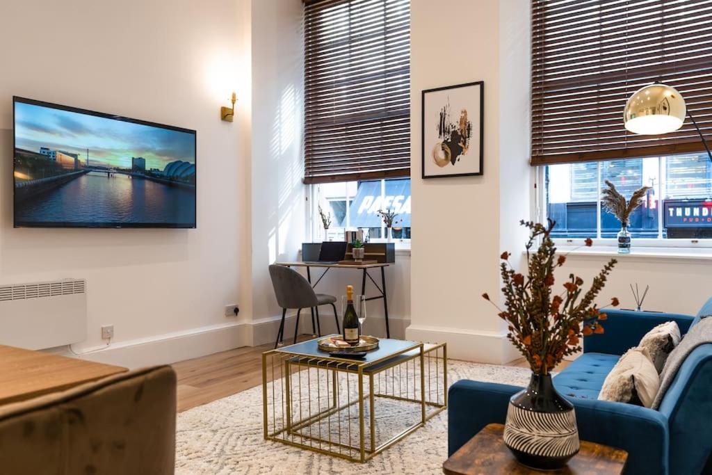 a living room with a blue couch and a table at The City Escape - 5* stay in the heart of Glasgow! in Glasgow