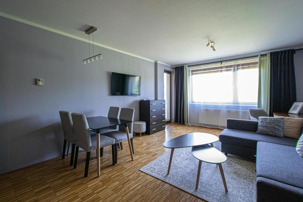 a living room with a table and a couch at Park View Apartman with private garage and balcony in Prague