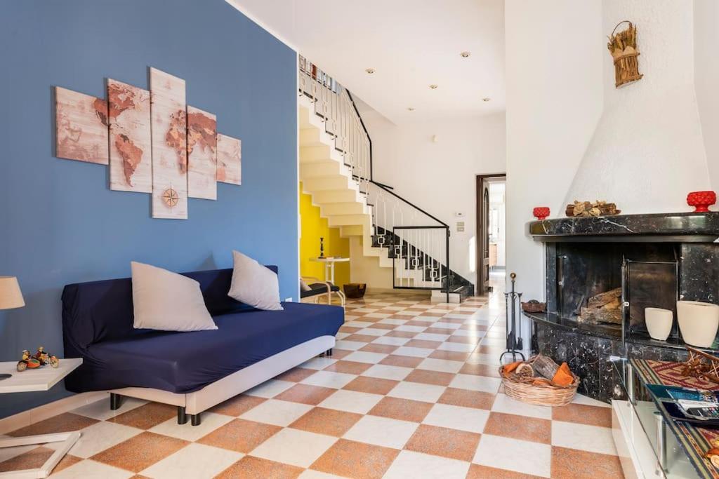 a living room with a blue couch and a fireplace at La Pomelia di Giò in Mondello