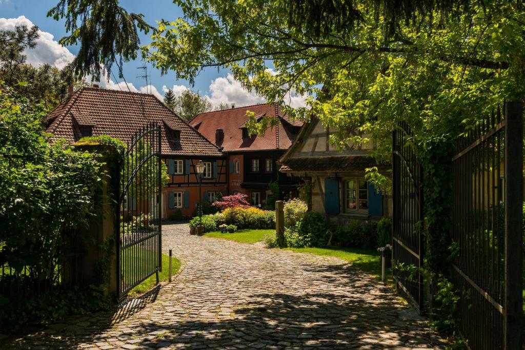 a driveway leading to a house with a gate at Hôtel le Moulin in Gundershoffen