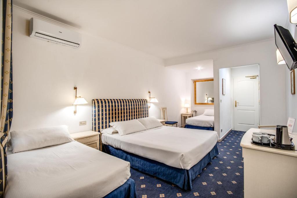 Postel nebo postele na pokoji v ubytování Hotel Napoleon