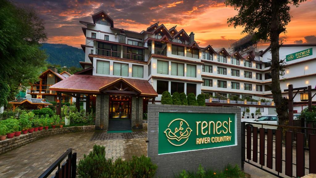 un hotel con un cartel frente a un edificio en Renest River Country Resort Manali, en Manali