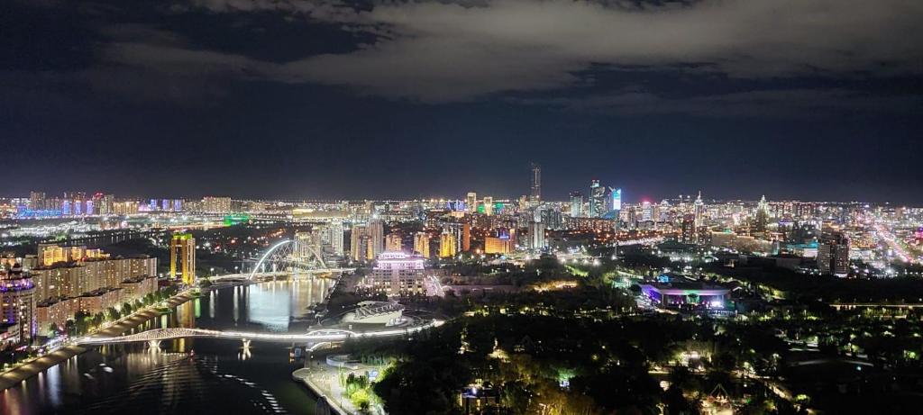 - Vistas a la ciudad por la noche y al río en Апартаменты на набережной с панорамным видом на 39 этаже, en Astana