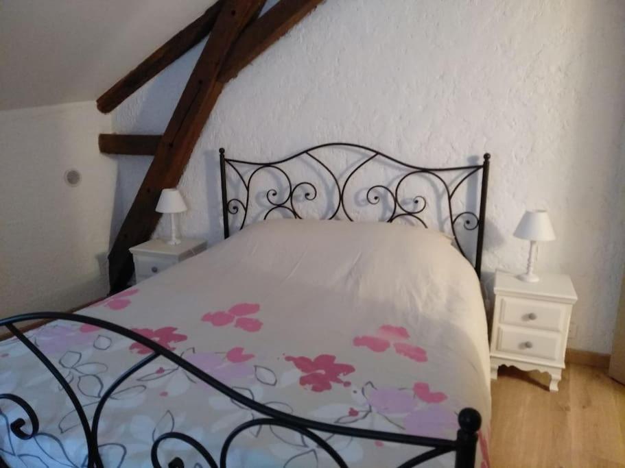 a bedroom with a bed and two night stands with lamps at La tour du logis, gîte 4 * à 15 min du Futuroscope 