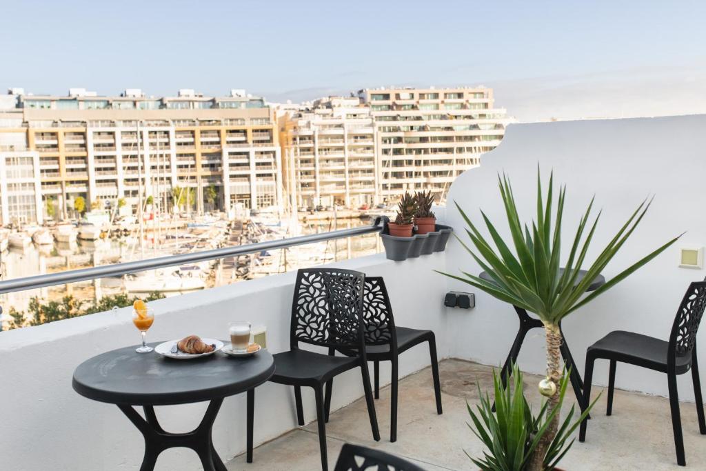 d'une table et de chaises sur un balcon avec vue. dans l'établissement Privilege Suite, à Tal-Pietà