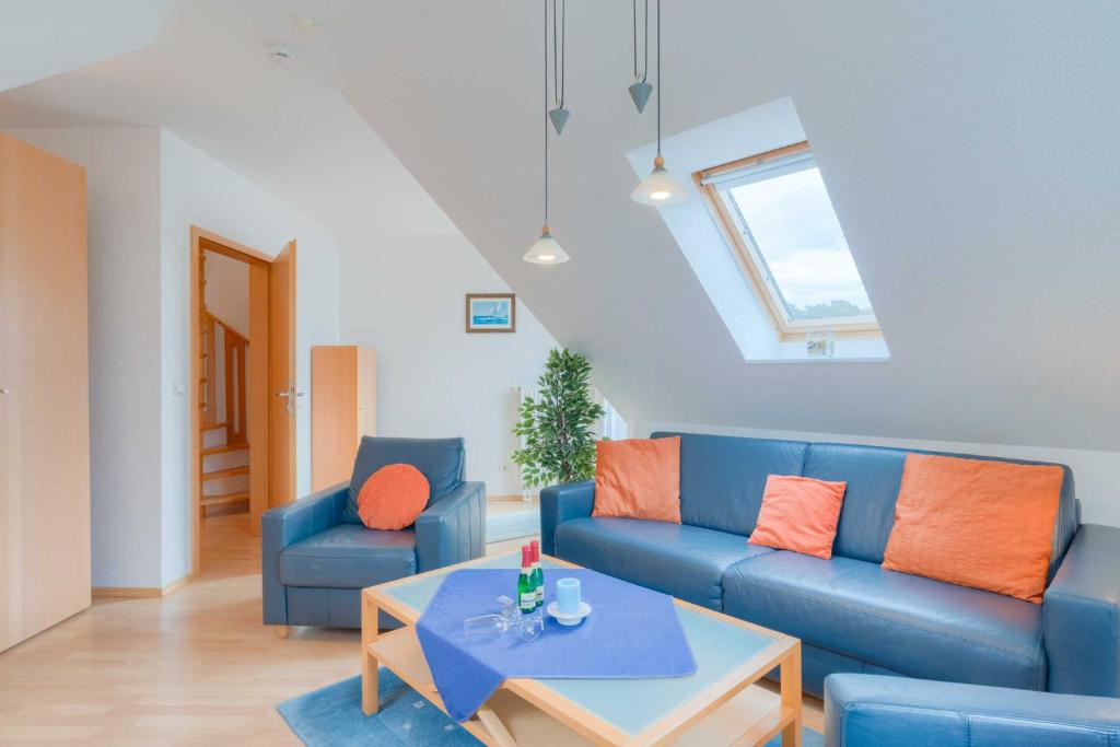 a living room with a blue couch and a table at Strandhaus Thiessow Whg_ 3 in Thiessow