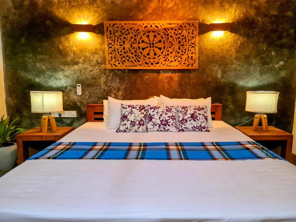 ein Schlafzimmer mit einem Bett mit zwei Lampen auf beiden Seiten in der Unterkunft sahasna (one bedroom private villa) in Unawatuna