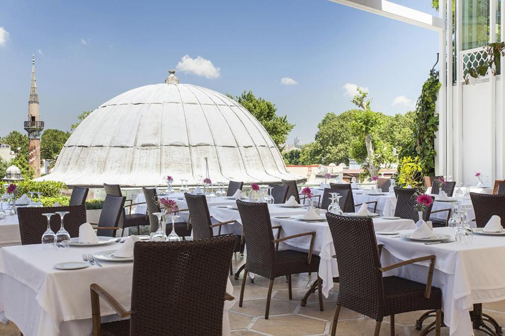 a restaurant with tables and chairs and umbrellas at Ottoman Hotel Imperial-Special Category in Istanbul