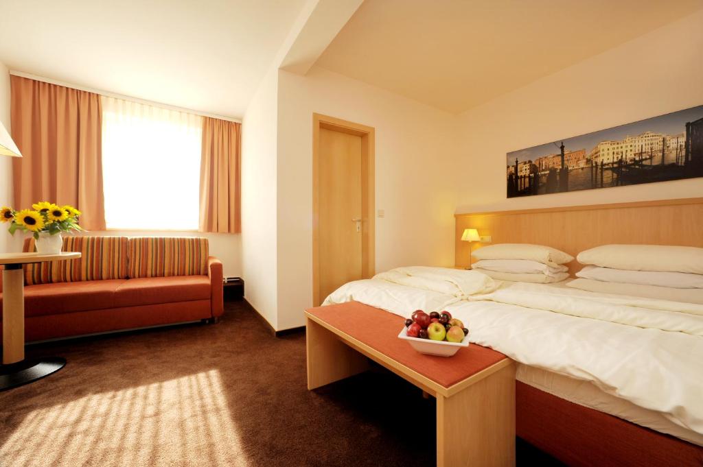 um quarto de hotel com uma cama e uma tigela de fruta numa mesa em Lübsche Thorweide em Wismar