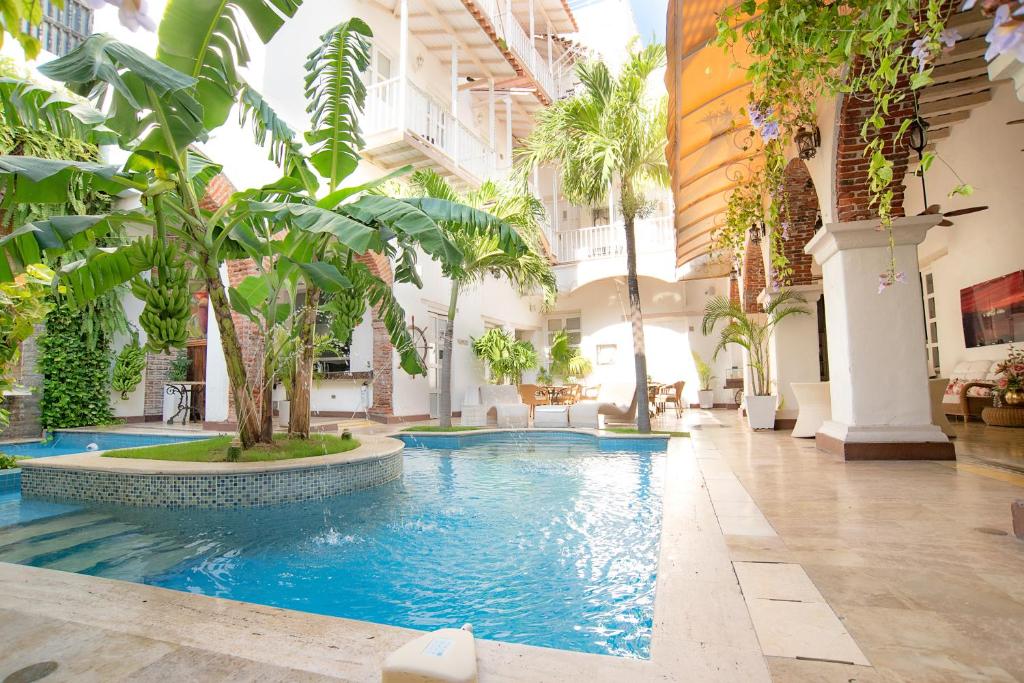 einen großen Innenhof mit Pool in einem Gebäude mit Bäumen in der Unterkunft Hotel Boutique Don Pepe in Santa Marta