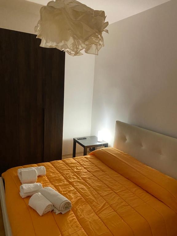 a bedroom with an orange bed with towels on it at Nic holiday house in Santa Marinella