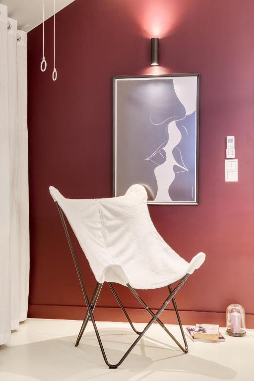 a white chair in a room with a red wall at Luxury Collection &amp; Resort in Cormeilles-en-Parisis