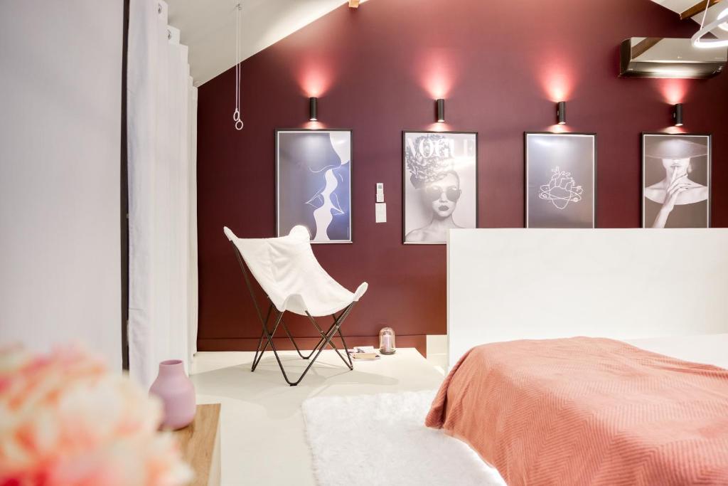 a bedroom with a bed and a chair and pictures on the wall at Luxury Collection &amp; Resort in Cormeilles-en-Parisis
