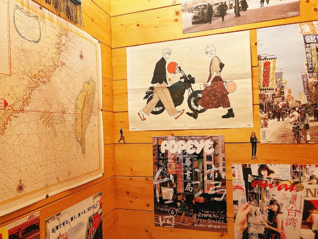 uma parede com cartazes e um mapa em Dock Inn em Tainan