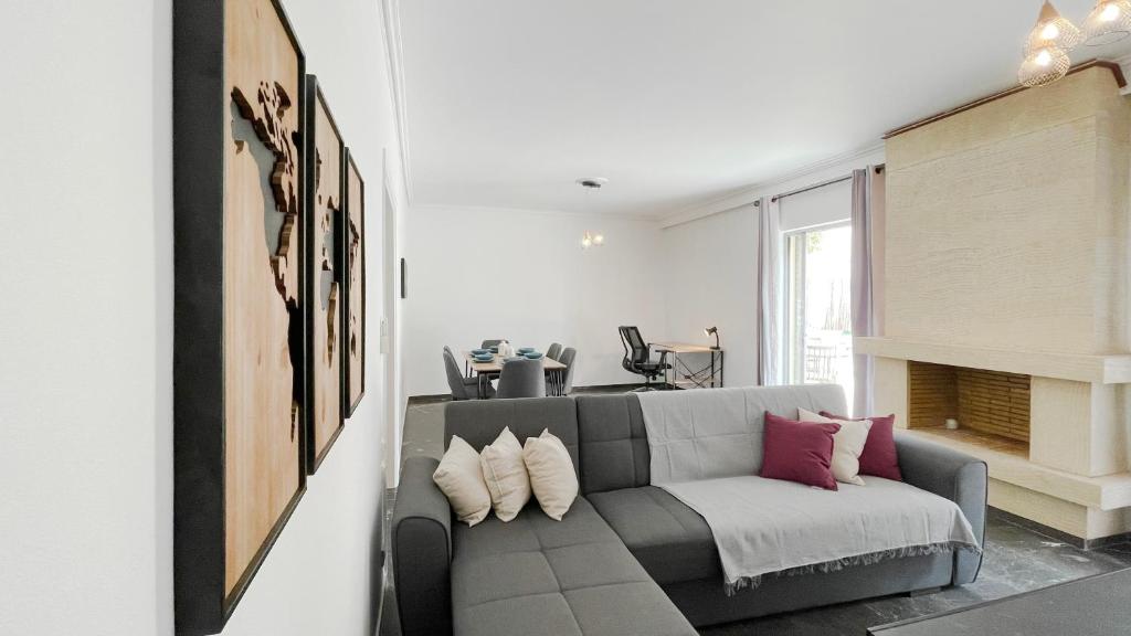 a living room with a gray couch with pillows at Filis Sunny 80sqm apt in Viktoria in Athens