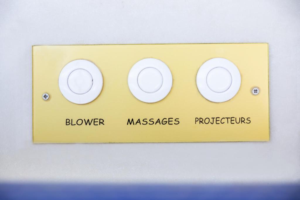 a yellow lightswitch with three gauges on a wall at Luxury Collection &amp; Resort in Cormeilles-en-Parisis