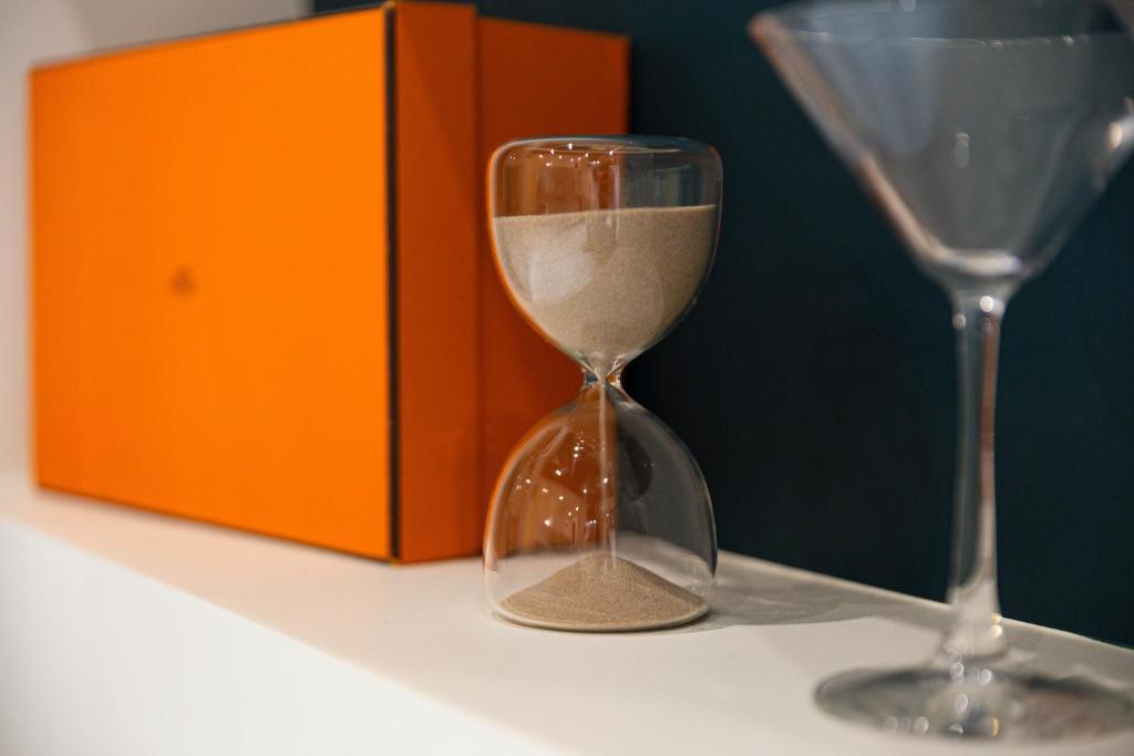 an hourglass sitting on a table next to an orange box at Luxury Collection &amp; Resort in Cormeilles-en-Parisis