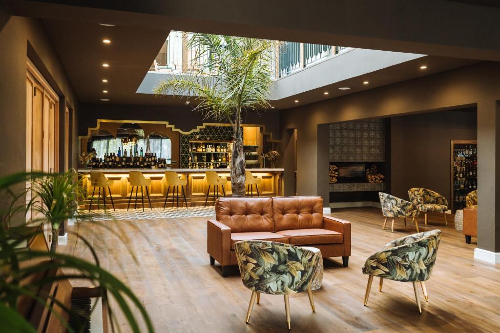 a lobby with a couch and chairs and a bar at The Hawthorn Boutique Hotel in George