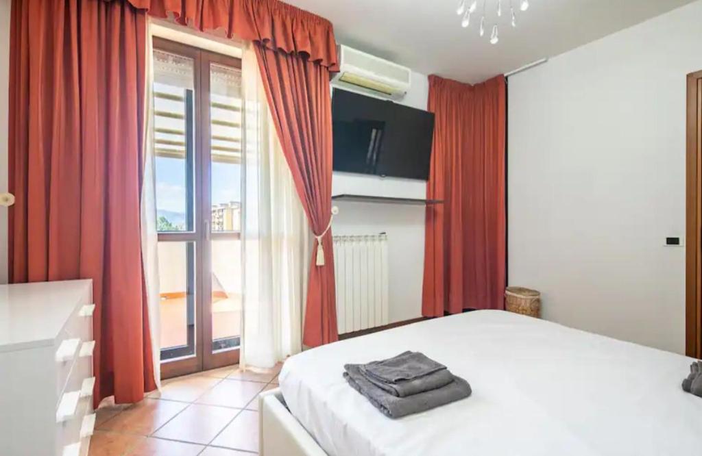 a bedroom with a bed with red curtains and a window at SUITE con 2 Balconi - 6 Guest in Prato