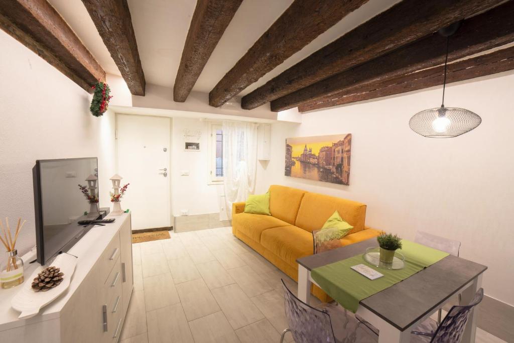 ein Wohnzimmer mit einem gelben Sofa und einem Tisch in der Unterkunft La Vida by Venicevillas in Venedig