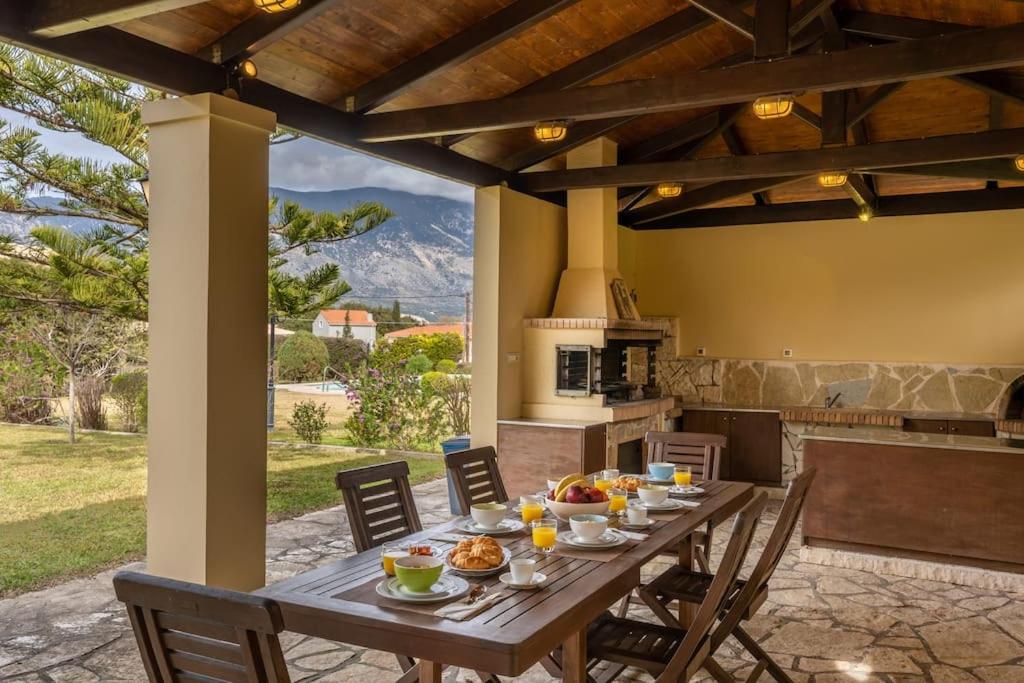 drewniany stół z jedzeniem na patio w obiekcie Villa Loukia w mieście Spartia