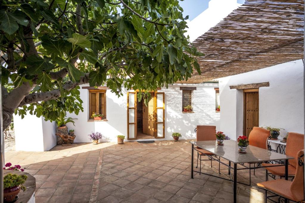 un patio de una casa con mesa y sillas en Algaba de Ronda, en Ronda