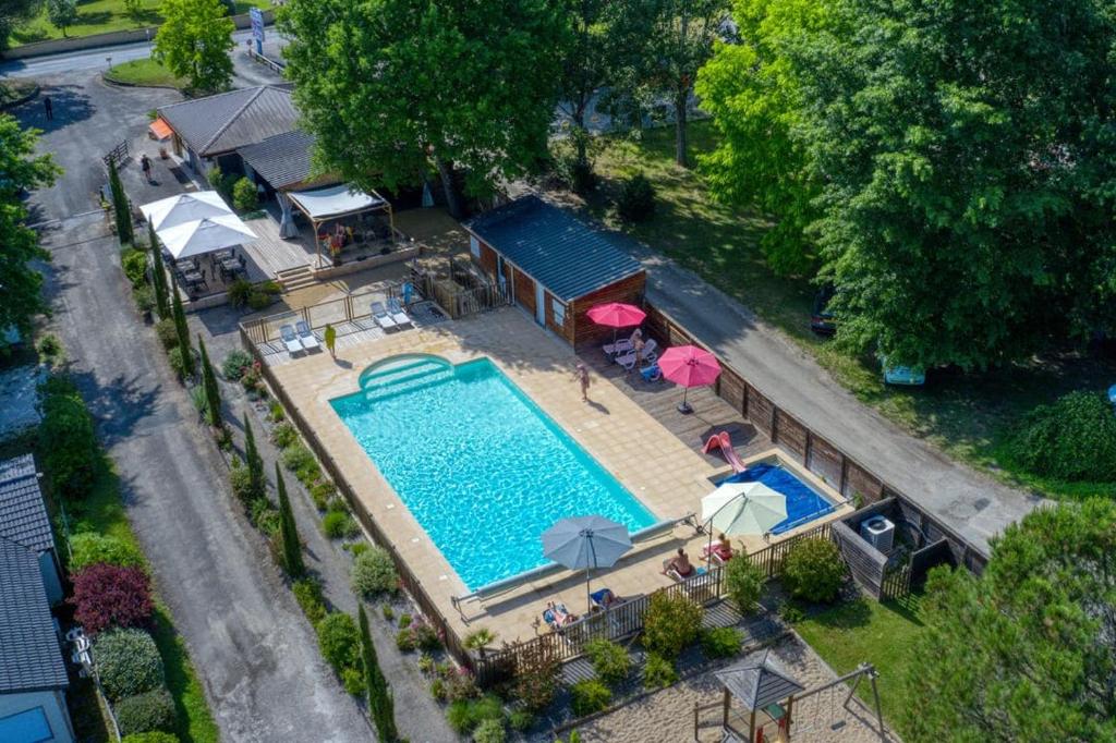 an overhead view of a swimming pool with umbrellas at Camping du Lac de Grolejac in Groléjac