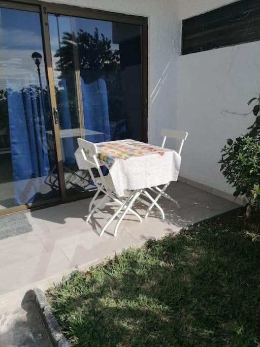 stół i 2 krzesła na patio w obiekcie Quiet & Bright Apartment with private garden w mieście Maspalomas