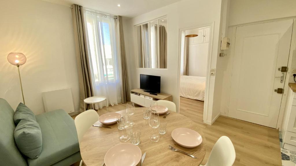 un salon avec une table, des chaises et une télévision dans l'établissement L'escapade, au Crotoy