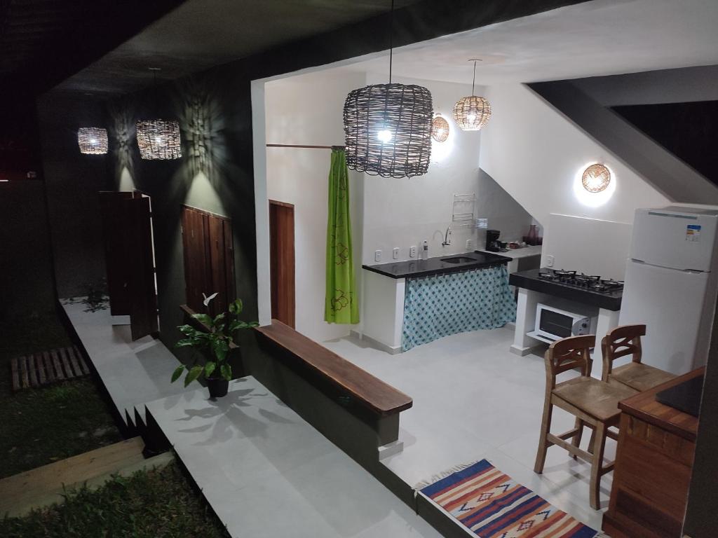 a kitchen and living room with a bench and a table at Casa do Artista in Trancoso