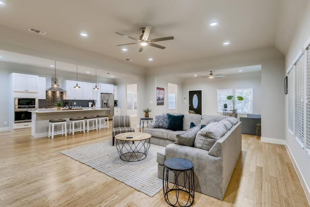 a living room with a couch and a kitchen at NEW 4 BDRM Home off St Mary’s Mins To Pearl/River! in San Antonio