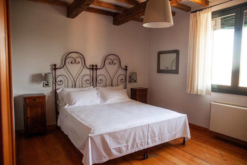 una camera da letto con un grande letto con lenzuola bianche di Agrilocanda Val Campotto ad Argenta