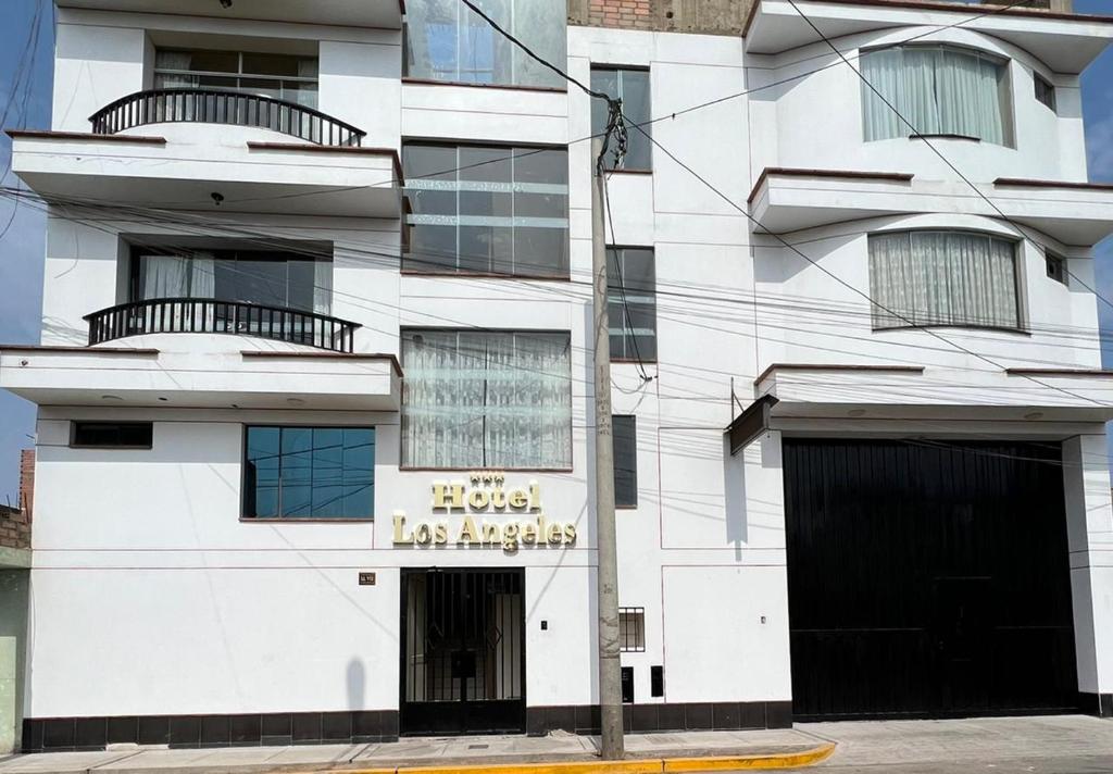 un edificio blanco con un letrero que lee hotel ángeles perezosos en Hotel los angeles, en Huaral