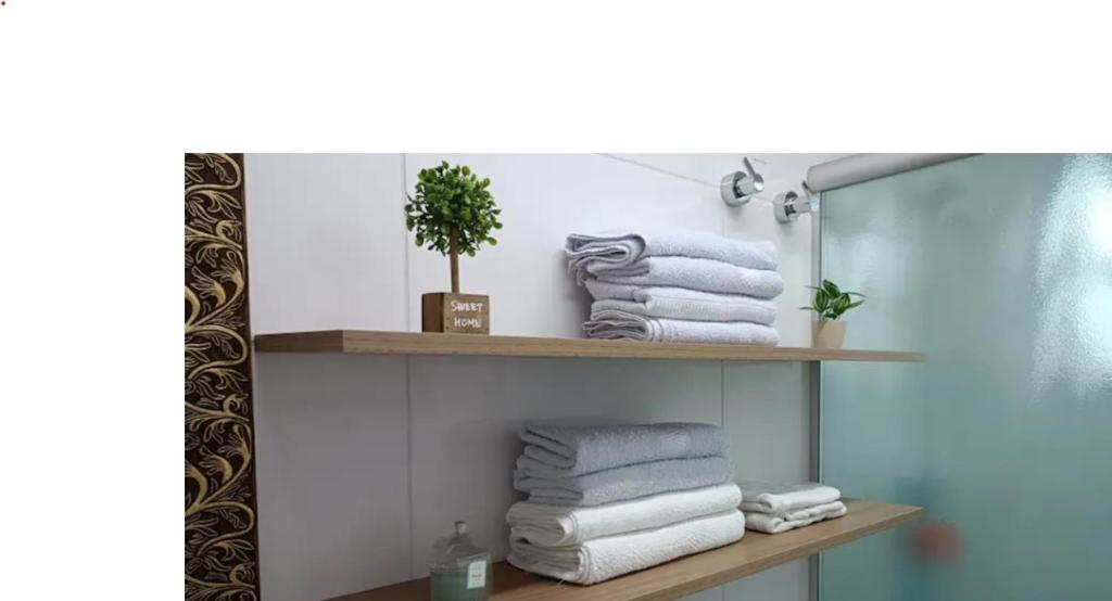 een stapel handdoeken op een plank in een badkamer bij Apartamento encantador no Gonzaguinha! Todo Reformado!! Completo! in São Vicente