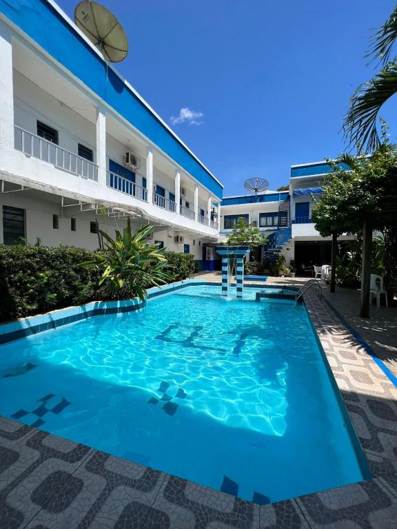 a swimming pool in front of a building at Regine's Hotel in Itaquatiara
