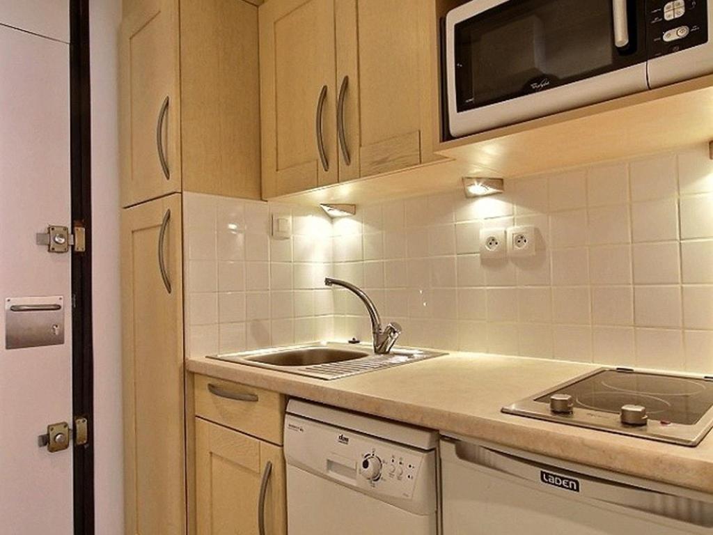 une petite cuisine avec un évier et un micro-ondes dans l'établissement Studio 3 pers. avec balcon, pied des pistes, galerie commerciale - Résidence Chamois, Aime 2000 - FR-1-455-19, à Aime La Plagne