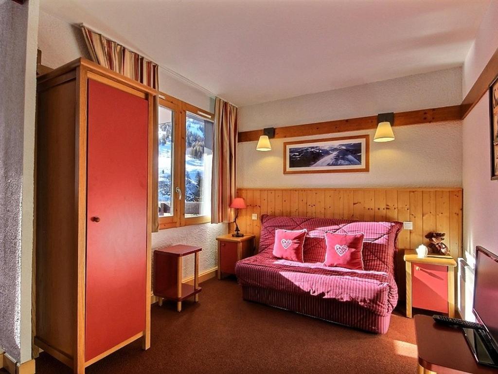 a bedroom with a pink bed with pink pillows at Studio-cabine 4 pers, proche pistes et commerces, balcon, piscine, 3 cristaux Paradiski - FR-1-455-27 in Plagne 1800