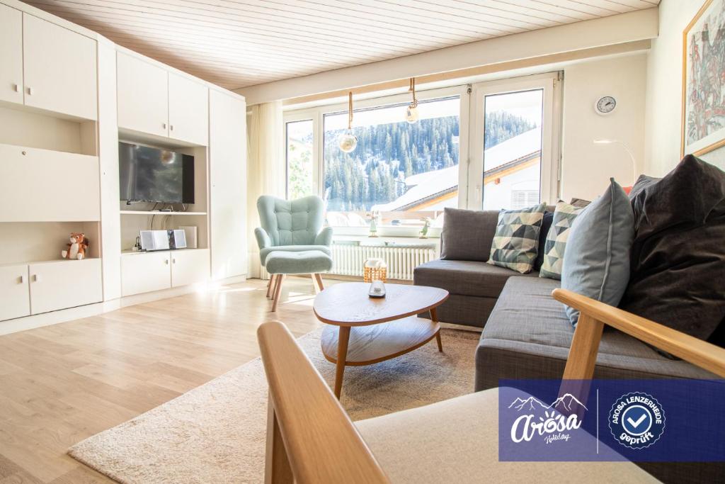 ein Wohnzimmer mit einem Sofa und einem Tisch in der Unterkunft Irmella 15 by Arosa Holiday in Arosa