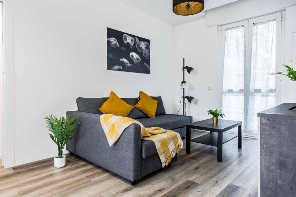 a living room with a gray couch and yellow pillows at 2 Bedrooms Apt with Terrace - NoLo area in Milan