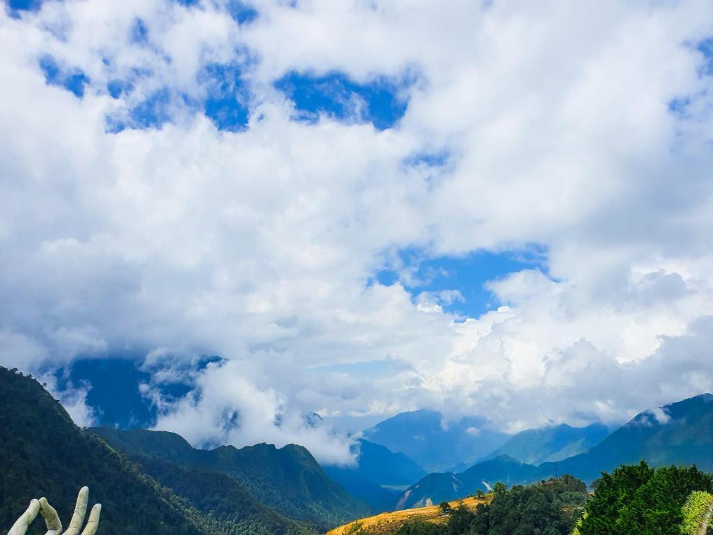 een uitzicht op de bergen onder een bewolkte hemel bij Phủ Giáng Vân Homestay Sapa in Sa Pa