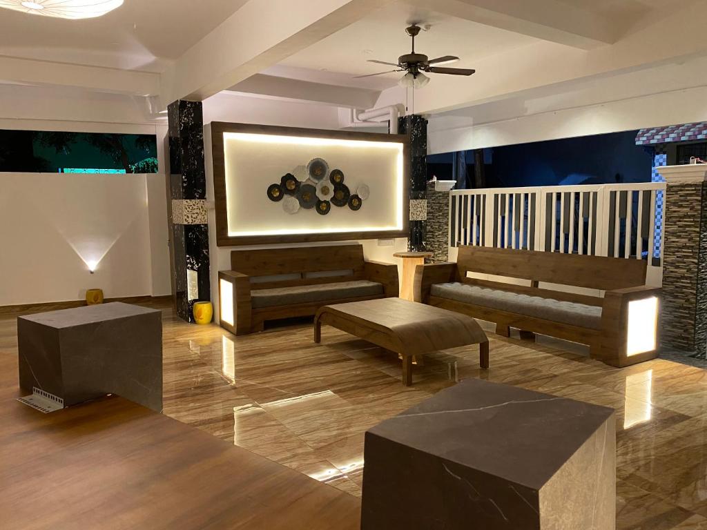 本地治里的住宿－Le Poshe Luxury，客厅配有沙发、桌子和绘画作品