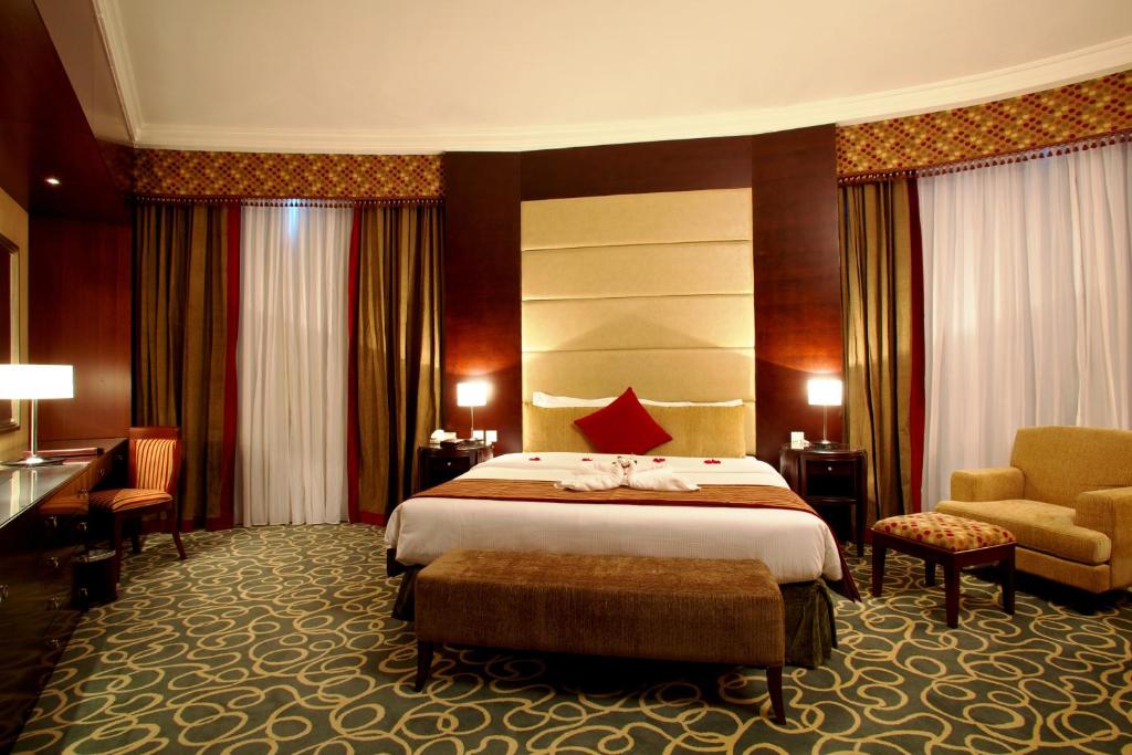 a hotel room with a bed and a chair at Concorde Hotel Fujairah in Fujairah
