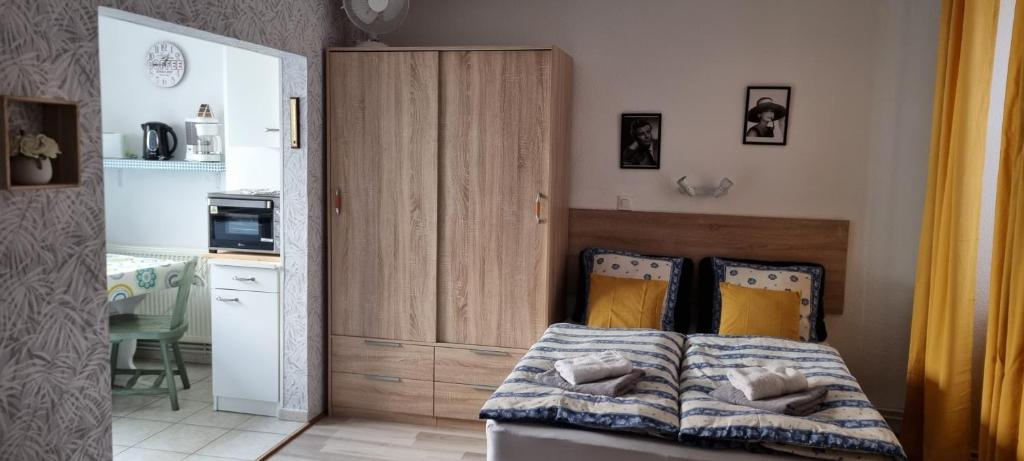 Habitación con cama y cocina con armario. en 1 rue des romains studio meublé clauss, en Niederbronn-les-Bains