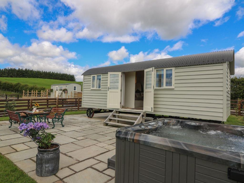 a tiny house on a patio with a hot tub at Hillside View in Rhayader