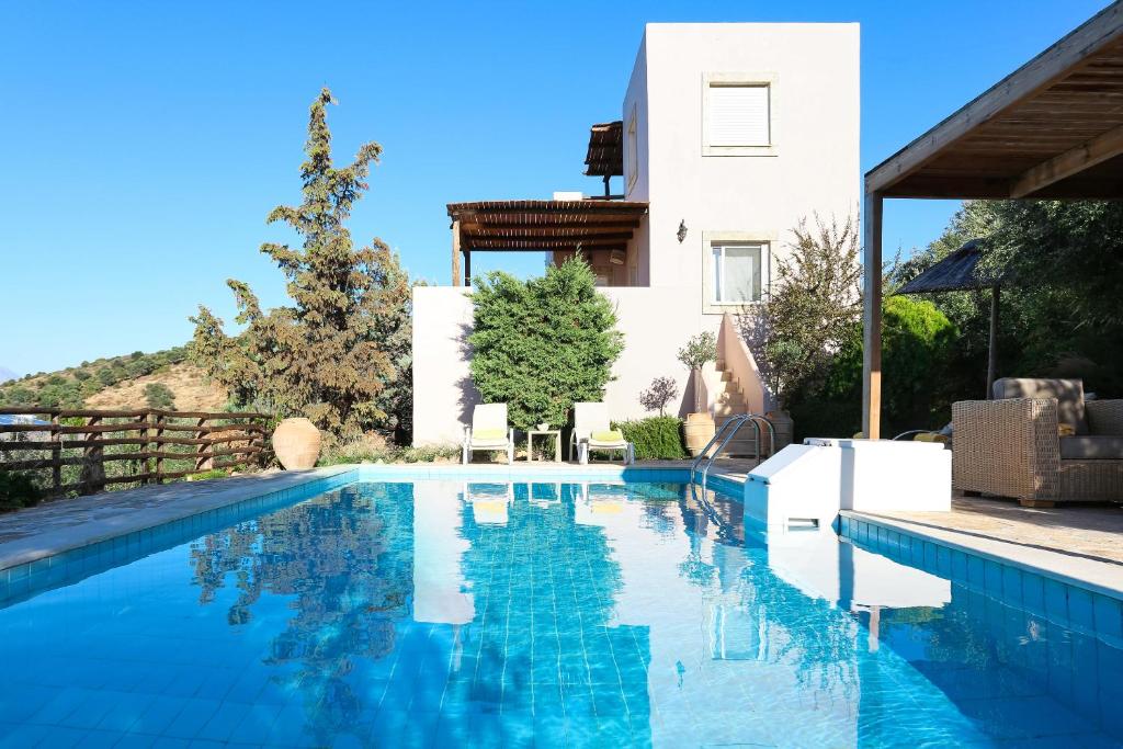 a swimming pool in front of a house at Listaros Villas in Lístaros