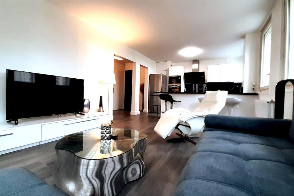 een woonkamer met een blauwe bank en een tv bij Spacious Apartment in Paris Place des Fetes in Parijs