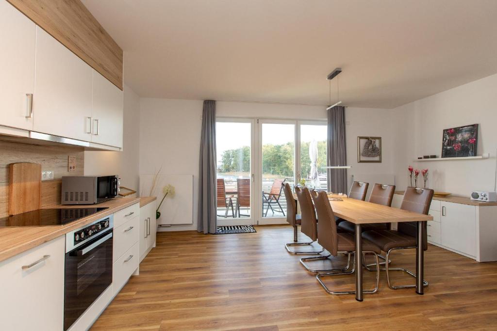 eine Küche und ein Esszimmer mit Tisch und Stühlen in der Unterkunft Becci's Apartment P6A8 in Plau am See