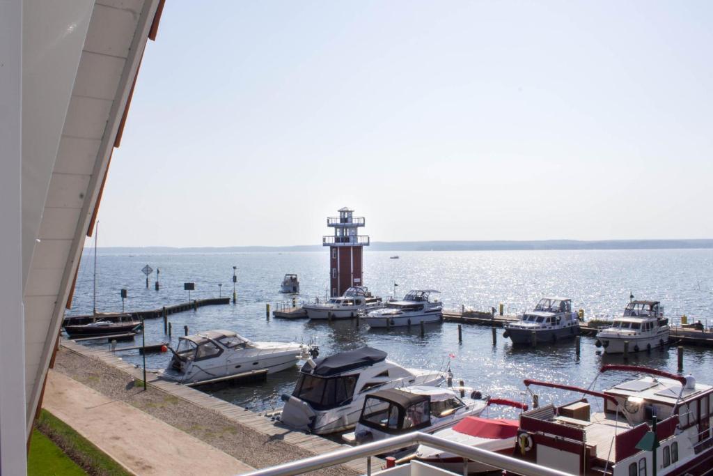 a group of boats docked at a dock with a lighthouse at 4 Zimmer Maisonette 3 Balkone Haus 7 A 6 in Plau am See