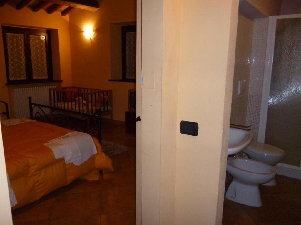 sypialnia z łóżkiem i łazienką z toaletą w obiekcie Agriturismo Ca'Verdeselle w mieście Fermignano